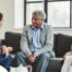 A caregiver talks with an elderly couple representing the kind of communication that professional caregivers need to have to anticipate client needs.