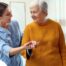 A caregiver helps a client get around, demonstrating one of the job duties of a caregiver.
