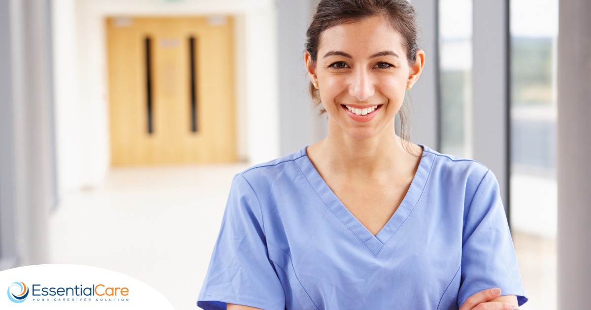 A woman in scrubs smiles, representing the good results that can come when caregivers branch out to become CNAs.