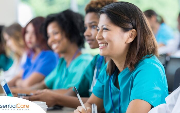 Several students in scrubs happily attend a class, representing caregiver training.