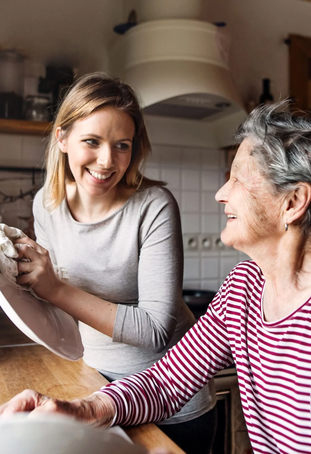 Caregiver helping an elderly woman with household tasks, representing dedicated in-home senior care in Centennial Hills